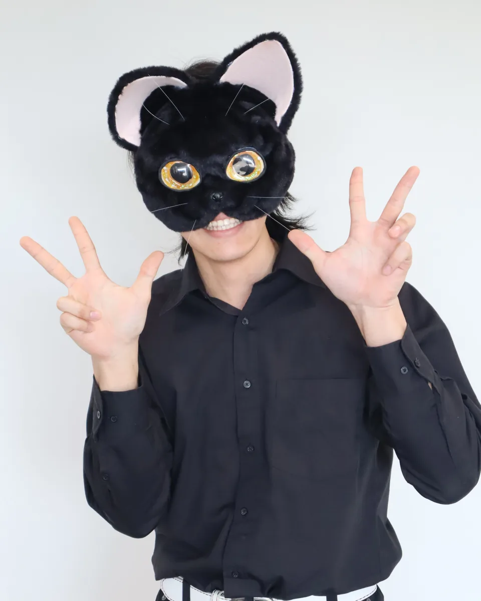 黒猫のかぶりものをつけて、両手を広げている三浦 蓮